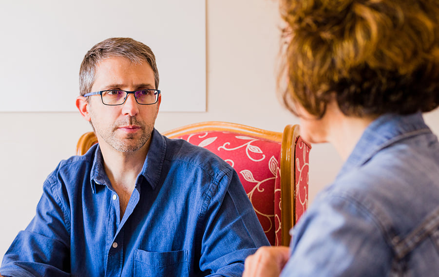 A patient with glasses staring at their physical therpaist as they speak