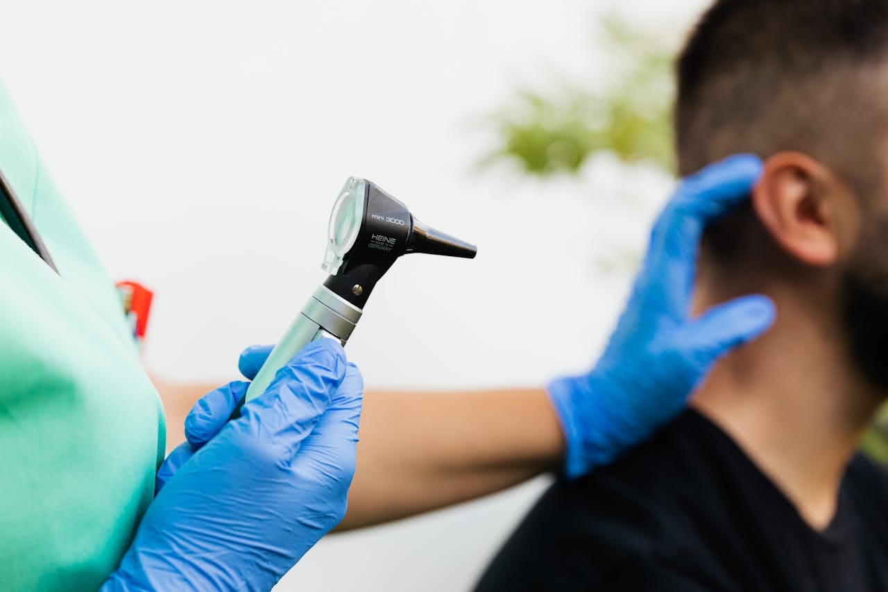 Provider performing ear examination with handheld otoscope during Alabama ENT appointment