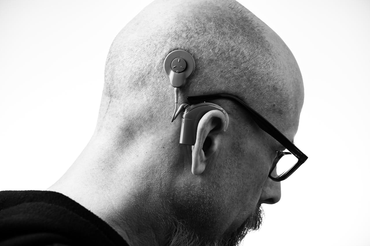 Man wearing hearing aid device during audiology treatment and hearing support consultation