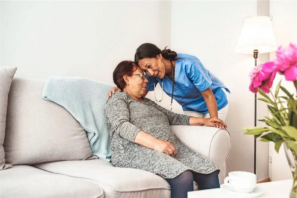 Caregiver hugging elderly