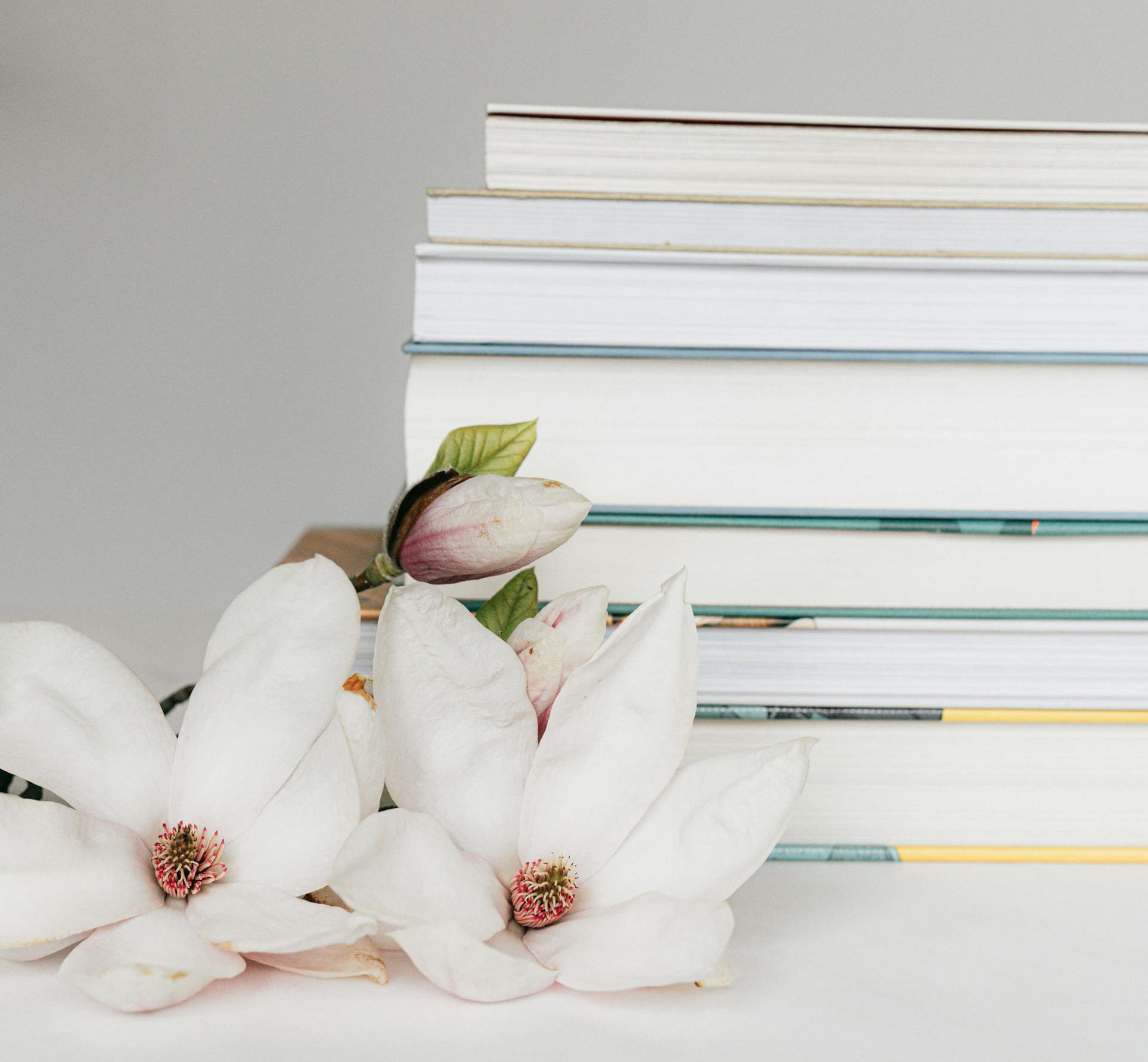 white flowers laying next to a stack of books