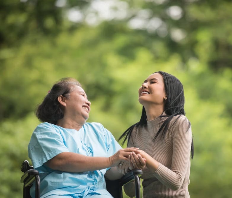 Granddaughter laughing with her elderly grandma while they enjoy nature