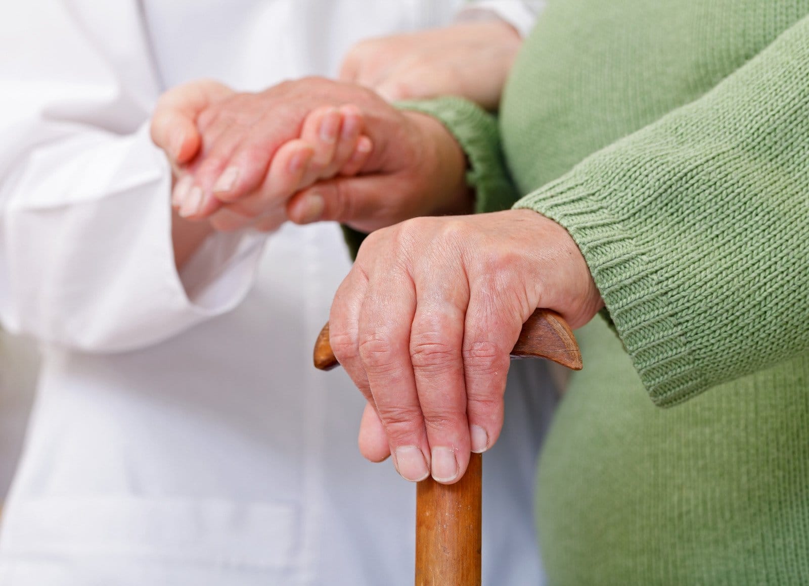 elderly home care nurse holding hand of a grandmother
