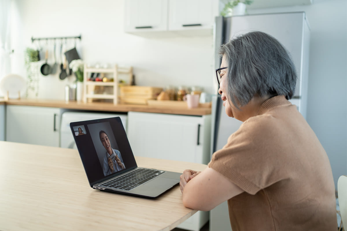 Older woman smiling while speaking to daughter on facetime