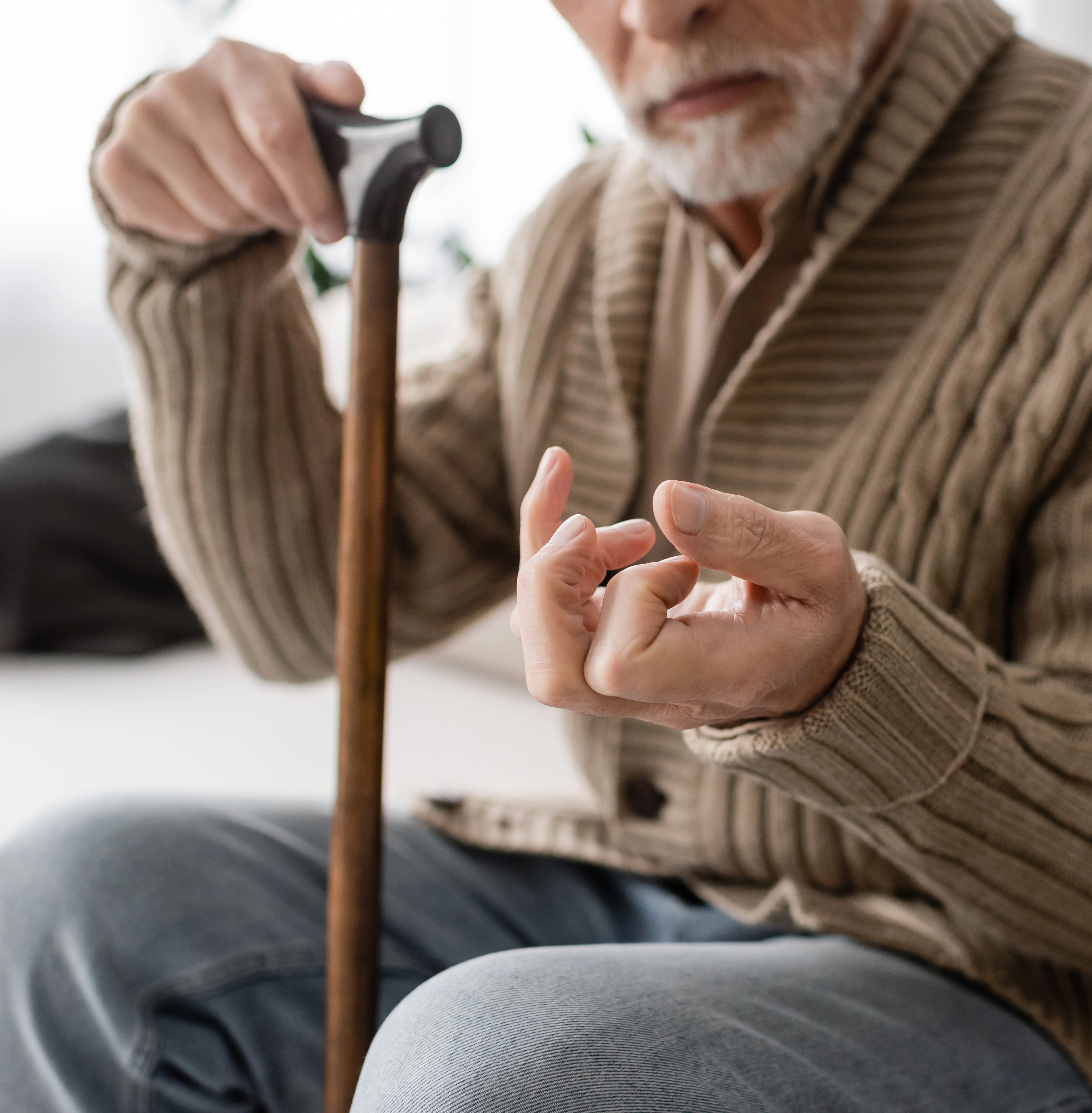 elderly man doing finger exercises on his left hand