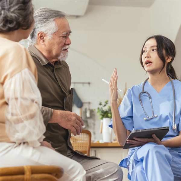 A sitting doctor explaining information to her elderly patient