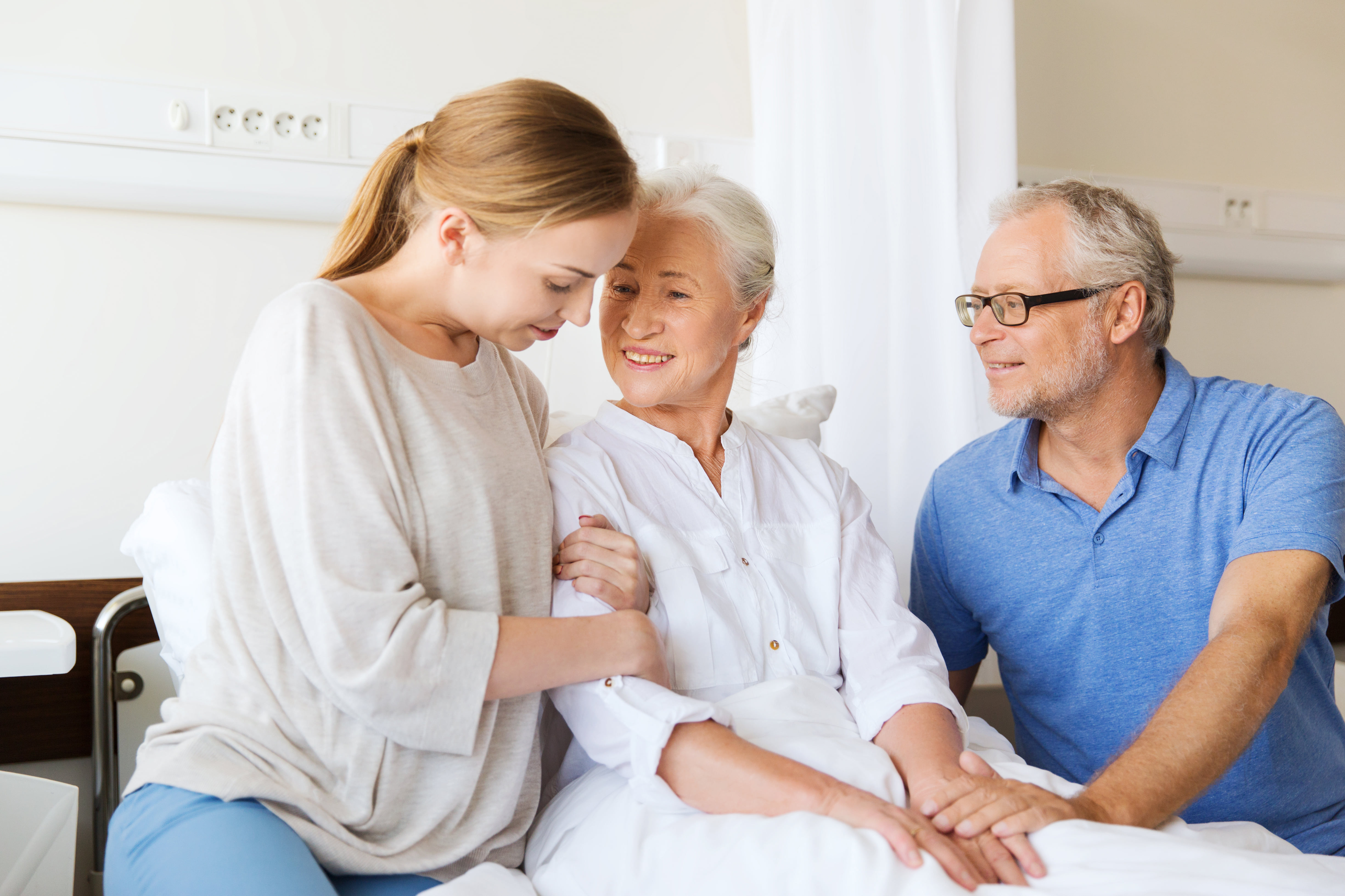 A hospice care patient sits with her family in a hospital room