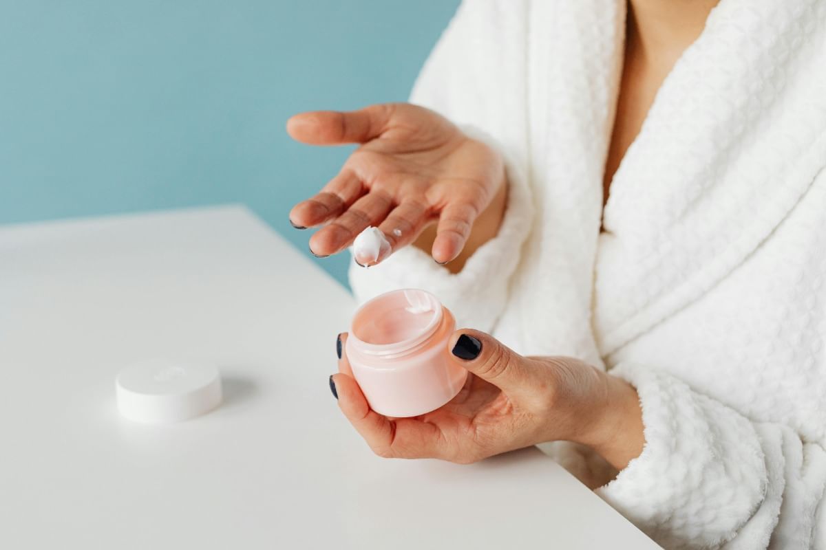 woman putting lotion on hand