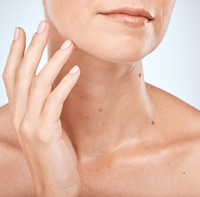 Woman touching her chin as she appears to gaze off into the distance
