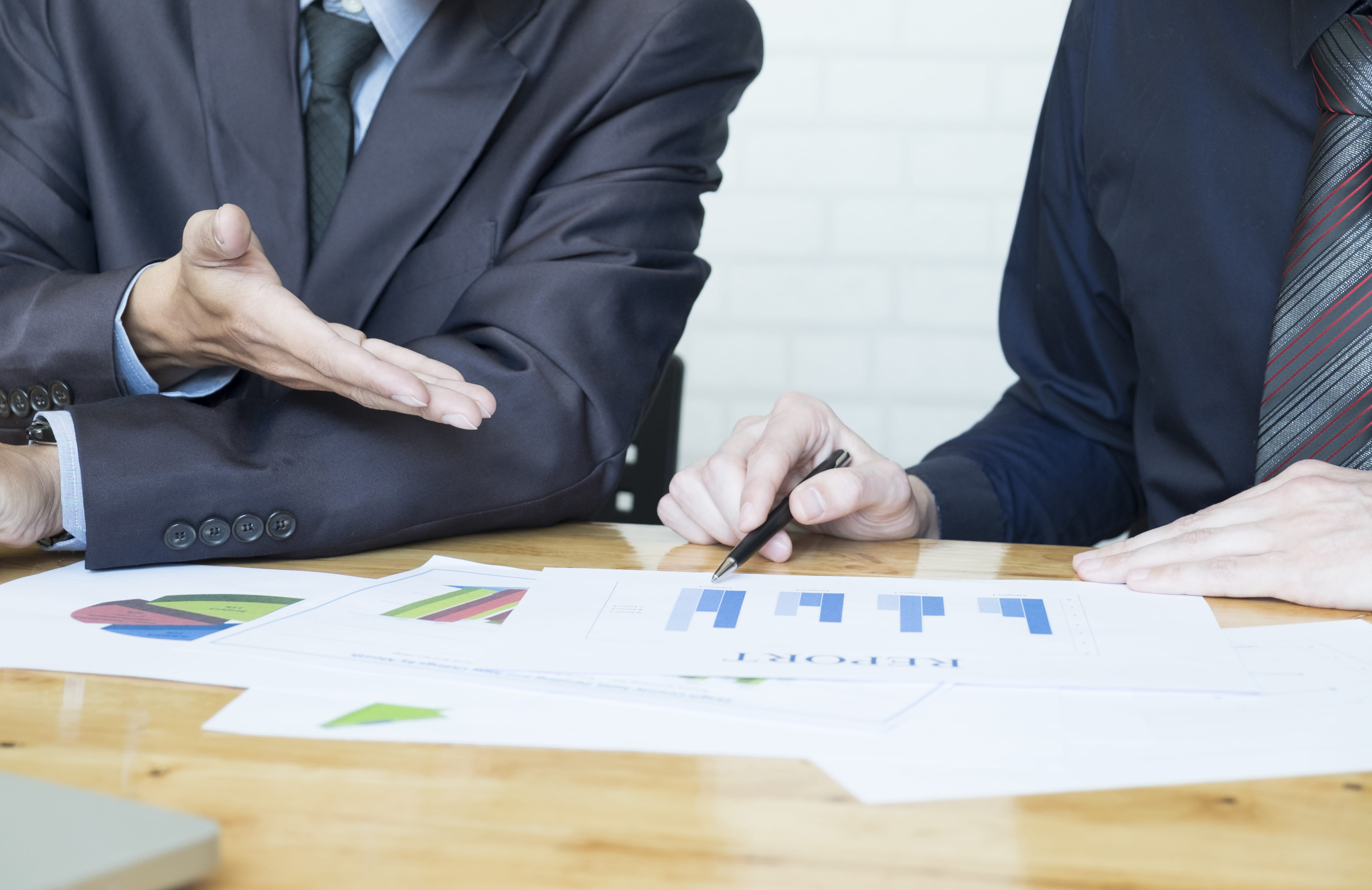 Attorney discussing property reports and charts during a real estate meeting Attorney discussing property reports and charts during a real estate meeting