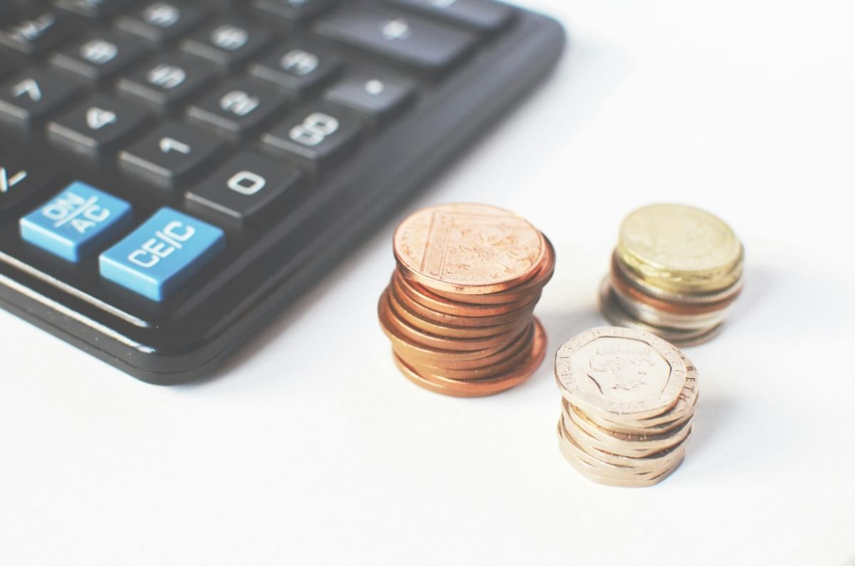 calculator sitting on desk next to coins