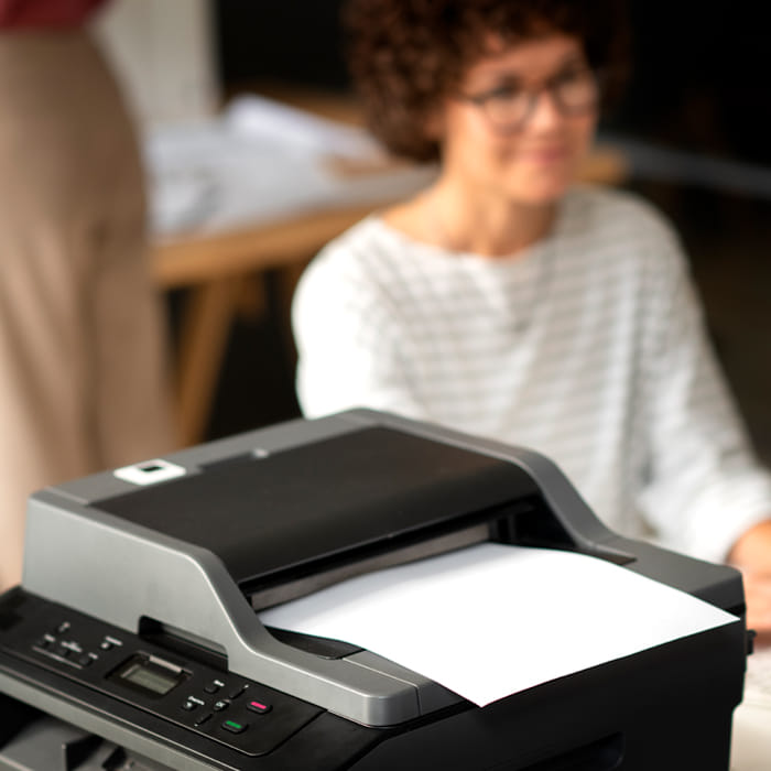 Office employee using a multifunction printer scanner for everyday document processing
