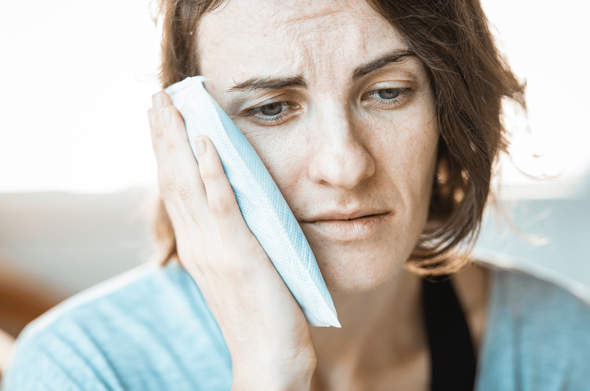 woman with jaw pain holding her face