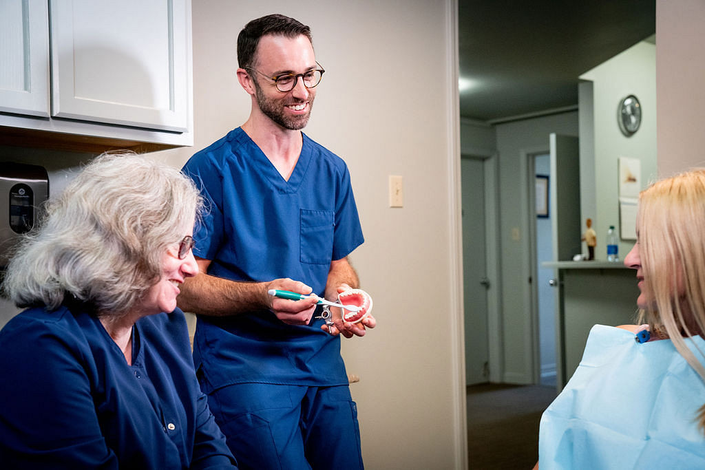 dentist and dental hygienist talking to patient