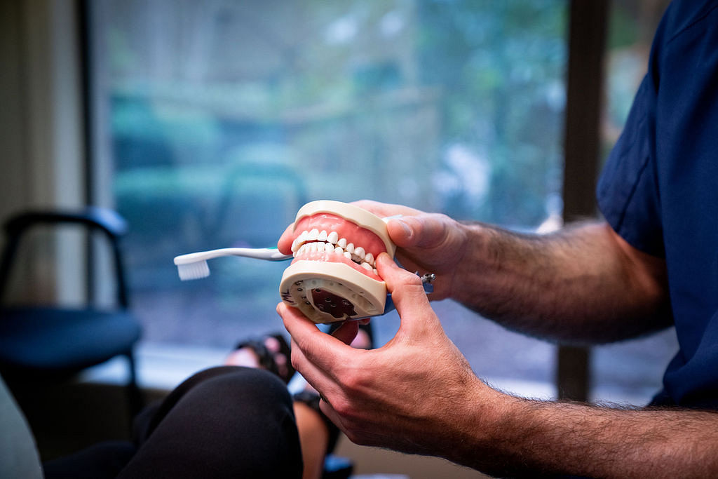 dentist explaining different types of bites using dental tool