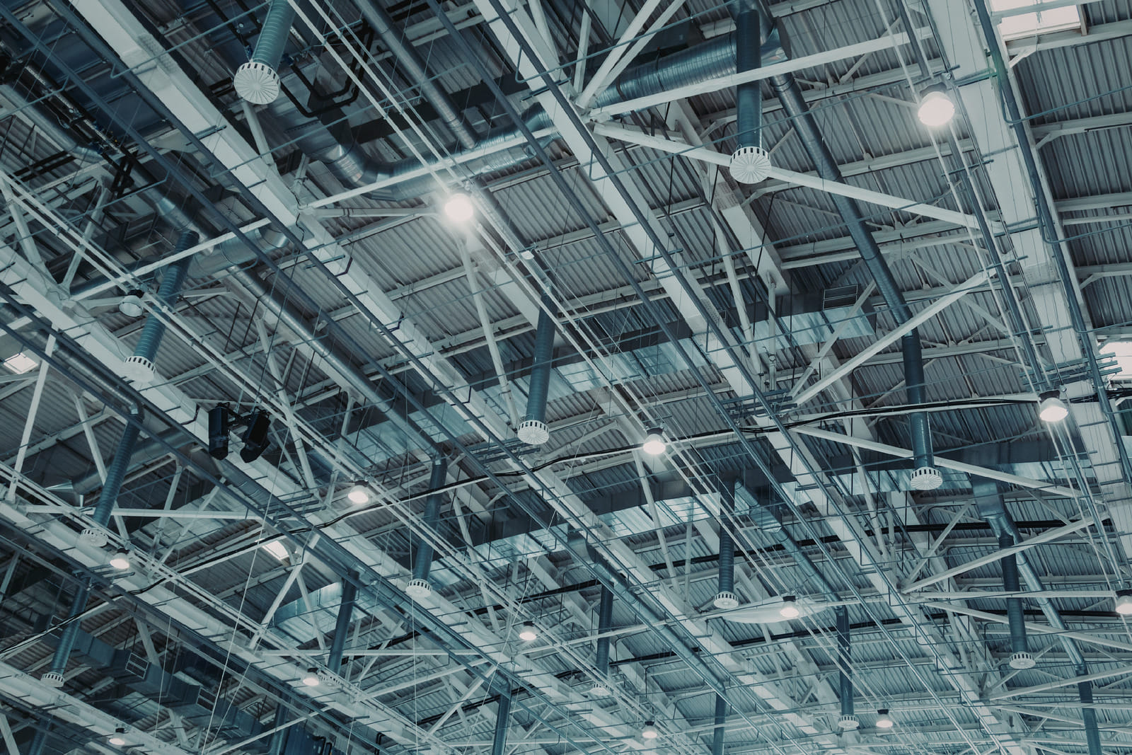 Industrial metal building interior with exposed steel structures and overhead lighting