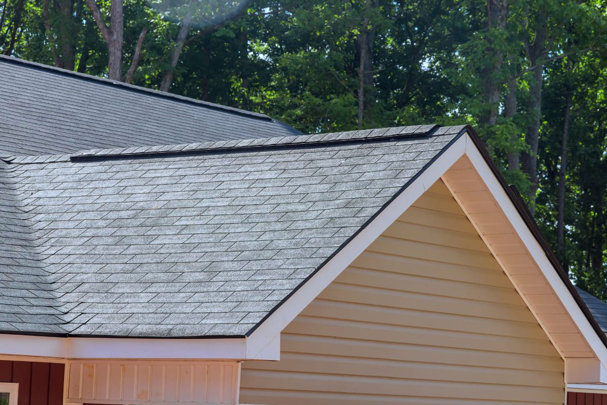 Clean asphalt shingle roof on residential home after proper roof maintenance