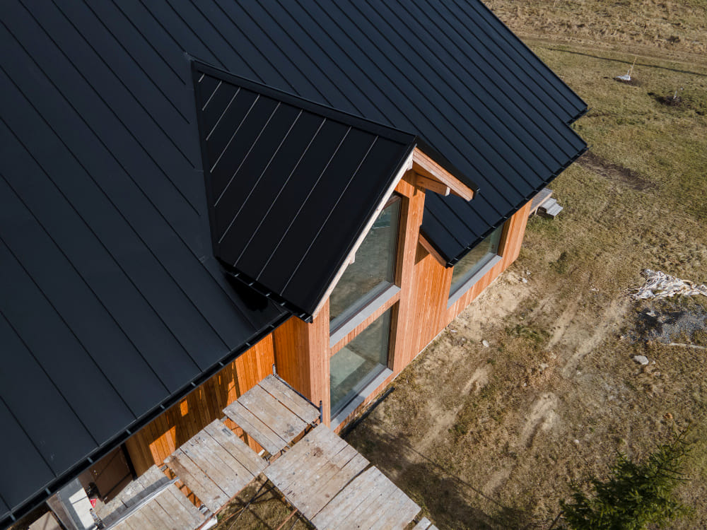 Modern home with black standing seam metal roofing installed on a residential property