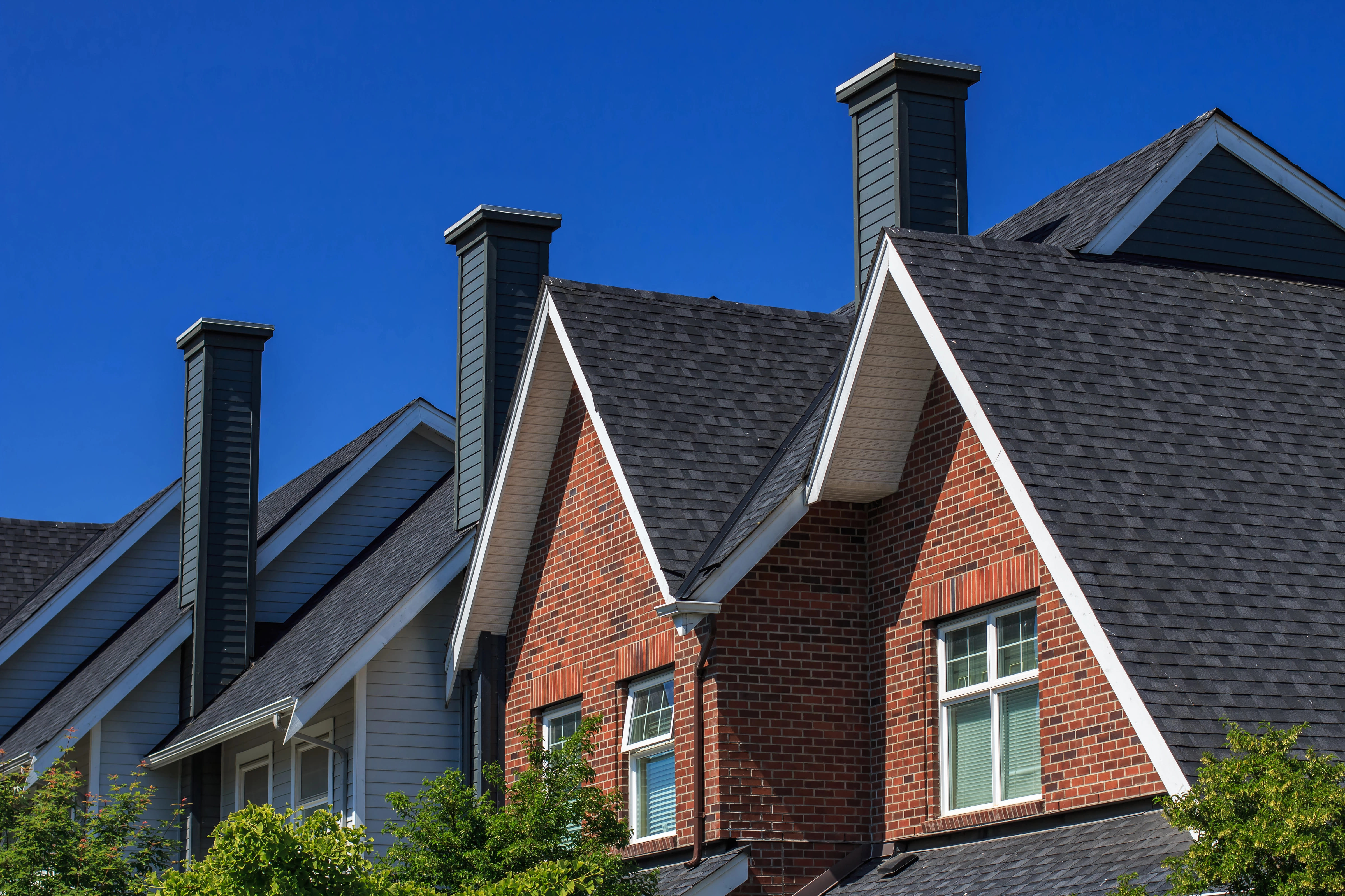 Two-story suburban home with beige siding, white trim, and an asphalt shingle roof. Two-story suburban home with beige siding, white trim, and an asphalt shingle roof.