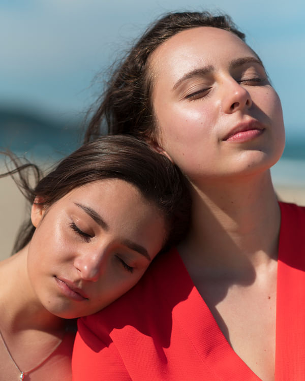 Two Woman sitting with their eyes closed so