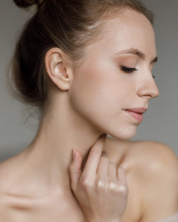 woman posing with fingers on her neck
