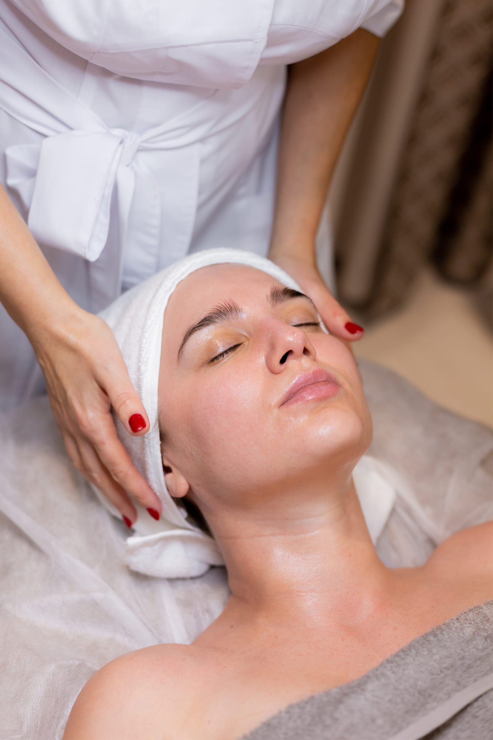 young woman relaxing while getting facial treatment