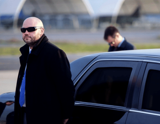 Security officerswaiting outside vehicle
