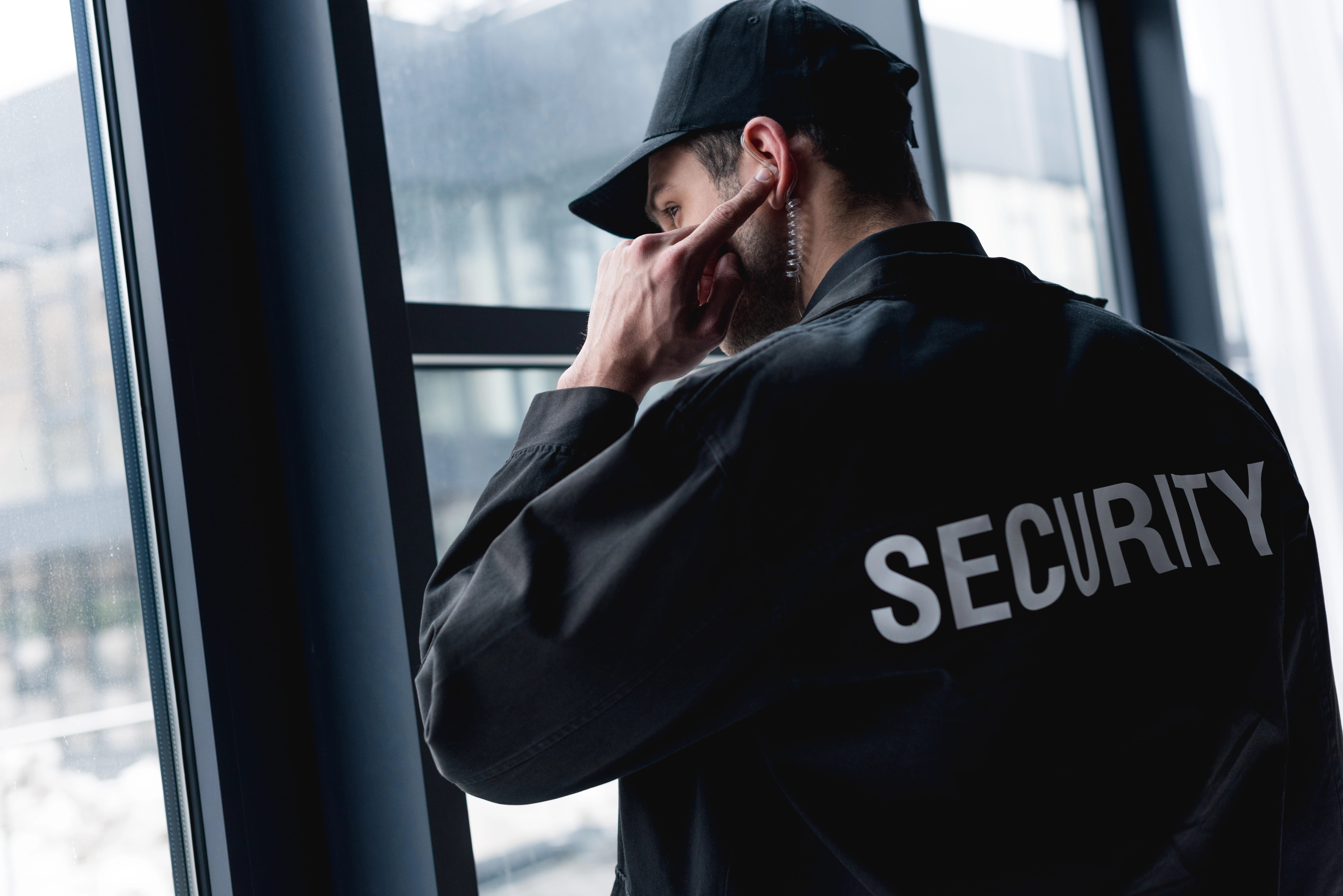 Security officer standing with arms crossed inside a facility, representing professional on-site presence.