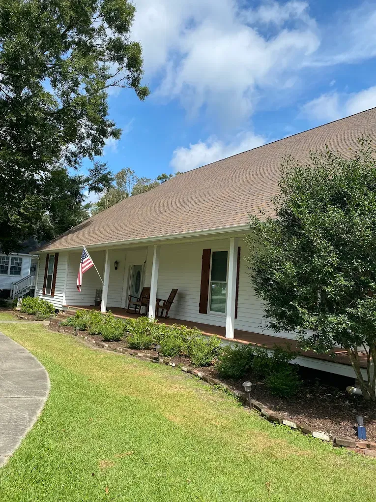 white panel home with gray brown shingles in Central, LA