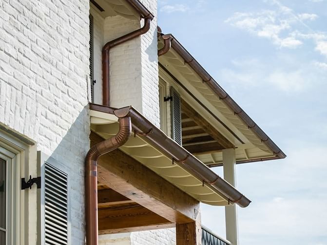 bronze colored gutters on white brick home in Baton Rouge, LA