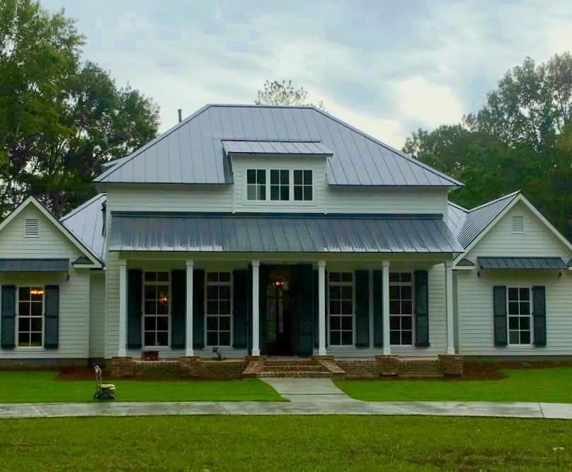 White house with a new metal roof installed by professional roofers in Central, LA