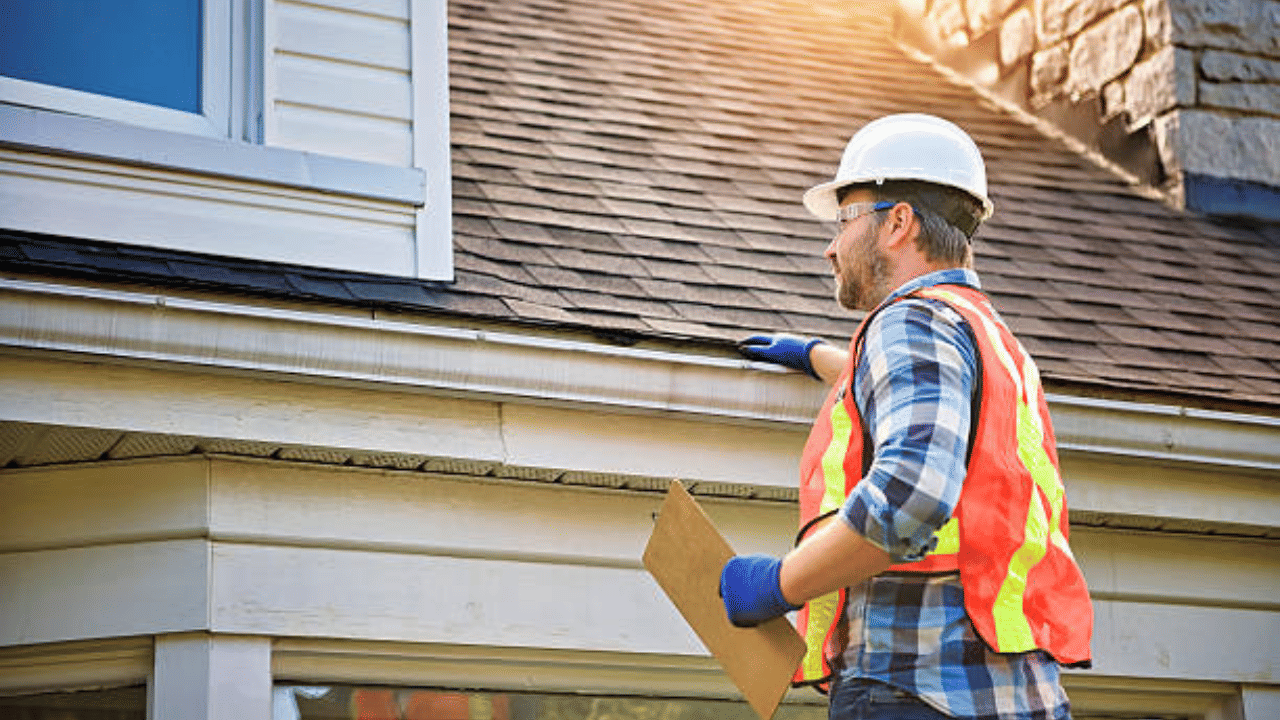 Roofing professional inspecting asphalt shingles on a Baton Rouge home